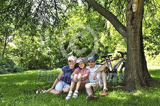 Family resting in summer park with bicycles