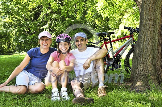 Family resting in summer park with bicycles Family resting in summer park with bicycles