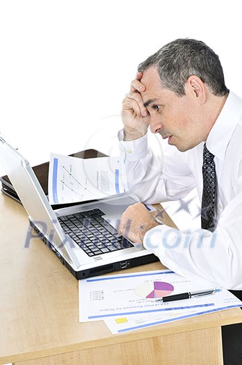 Stressed businessman sitting at his desk isolated on white background Stressed businessman sitting at his desk isolated on white background