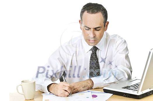 Serious office worker reviewing generic reports at his desk Serious office worker reviewing generic reports at his desk