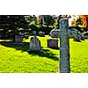 Bright graveyard lawn with ancient tombstone crosses