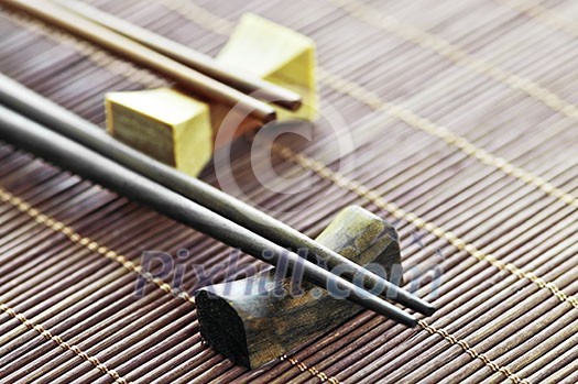 Two sets of wooden chopsticks on rests close up Two sets of wooden chopsticks on rests close up