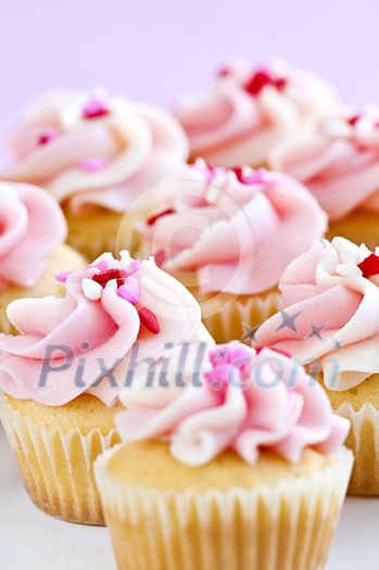 Lots of tasty cupcakes with icing and sprinkles Lots of tasty cupcakes with icing and sprinkles