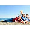 Happy family laying on towel at sandy beach