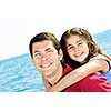 Portrait of father giving piggyback ride to daughter at seashore