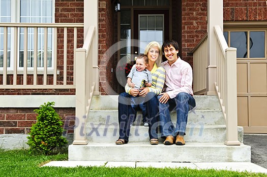 Young family sitting on front steps of house Young family sitting on front steps of house