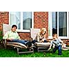 Happy family relaxing in backyard of new home with toddler