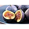 Closeup view of figs sliced in half on a blue plate