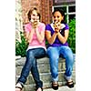 Two teenage girls sitting and eating pizza