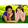 Two happy teenage girls laying on grass