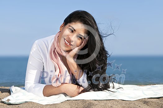 Portrait of beautiful smiling native american girl laying at beach Portrait of beautiful smiling native american girl laying at beach