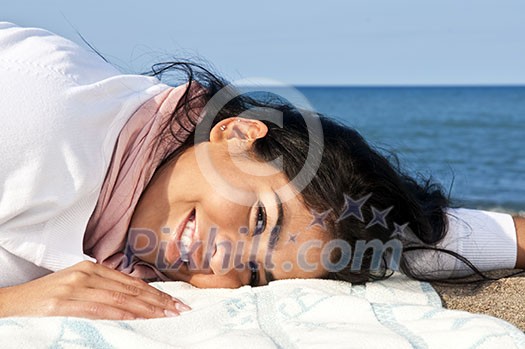 Portrait of beautiful smiling native american girl laying at beach Portrait of beautiful smiling native american girl laying at beach