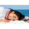 Portrait of beautiful smiling native american girl laying at beach