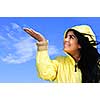 Portrait of beautiful smiling girl wearing yellow raincoat looking up checking for rain