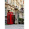Red telephone box near old buildings in London