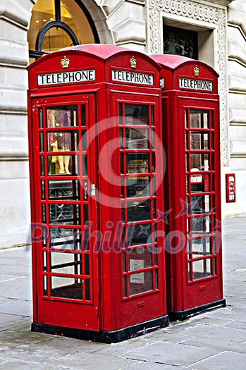 Two red telephone boxes near on London sidewalk Two red telephone boxes near on London sidewalk