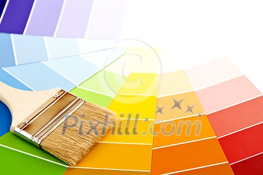 Clean paintbrush on rainbow of color card samples Clean paintbrush on rainbow of color card samples