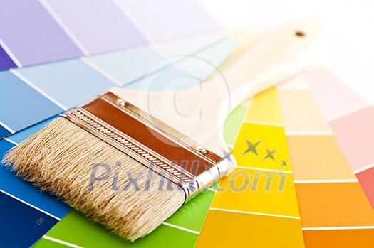 Clean paintbrush on rainbow of color card samples Clean paintbrush on rainbow of color card samples