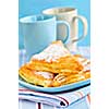 Apple turnovers pastries with coffee cups in the background