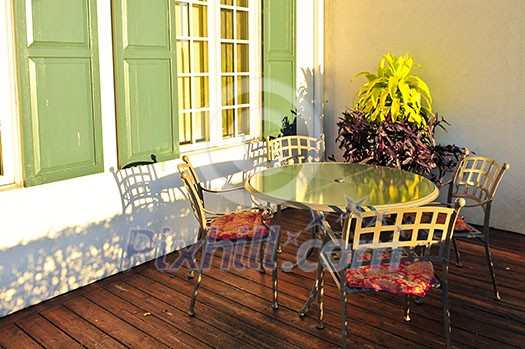 Patio chairs and tables on wooden patio deck Patio chairs and tables on wooden patio deck