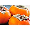 Orange whole ripe persimmon fruit on a plate