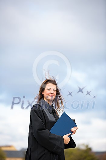Pretty, young woman celebrating joyfully her graduation - spreading wide her arms, holding her diploma, savouring her success (color toned image; shallow DOF) Pretty, young woman celebrating joyfully her graduation - spreading wide her arms, holding her diploma, savouring her success (color toned image; shallow DOF)