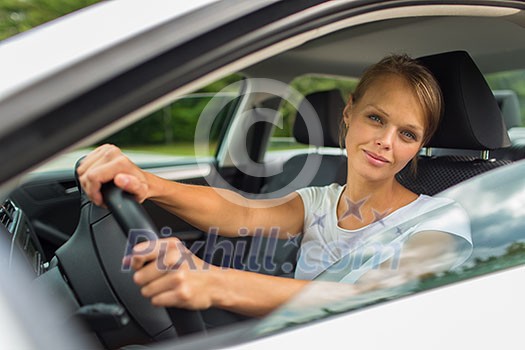 Young woman driving her car, on her way home from work - doing the daily commute Young woman driving her car, on her way home from work - doing the daily commute