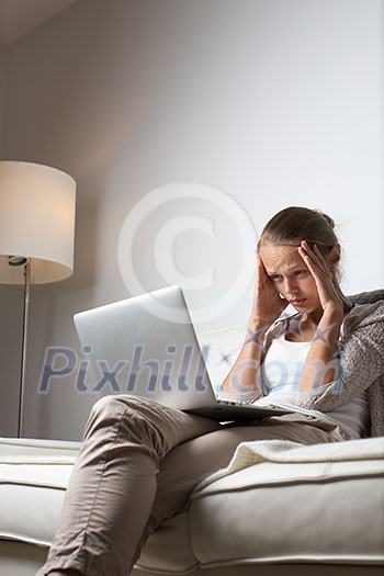 Very tired young woman, burning the midnigh oil - working late at night on her laptop computer, at home, sitting on sofa, rubbing her tired eyes, trying to stay focused Very tired young woman, burning the midnigh oil - working late at night on her laptop computer, at home, sitting on sofa, rubbing her tired eyes, trying to stay focused