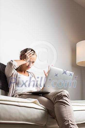 Very tired young woman, burning the midnigh oil - working late at night on her laptop computer, at home, sitting on sofa, rubbing her tired eyes, trying to stay focused Very tired young woman, burning the midnigh oil - working late at night on her laptop computer, at home, sitting on sofa, rubbing her tired eyes, trying to stay focused