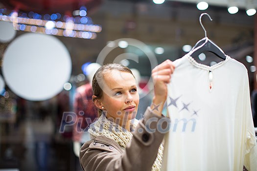 Young woman shopping in a fashion store (color toned image; shallow DOF) Young woman shopping in a fashion store (color toned image; shallow DOF)