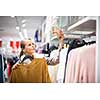 Young woman shopping in a fashion store (color toned image; shallow DOF)