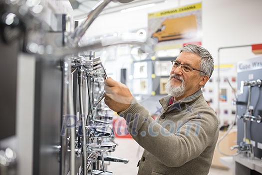 Senior man choosing a bathroom/kitchen tap in a home furnishings retail store Senior man choosing a bathroom/kitchen tap in a home furnishings retail store