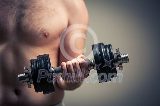 Close up of young man lifting weights over grey background Close up of young man lifting weights over grey background