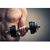 Close up of young man lifting weights over grey background