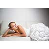 Beautiful bride lying on a sofa, looking pensive