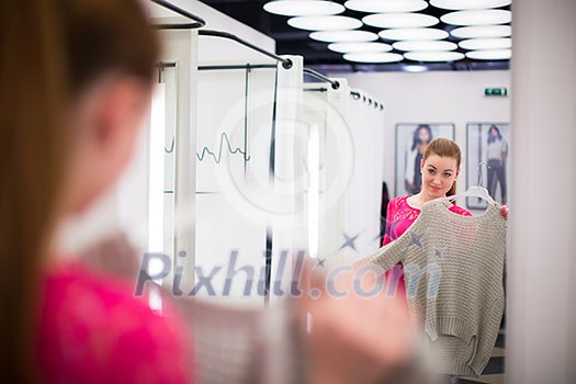 Young woman shopping in a fashion store (color toned image; shallow DOF) Young woman shopping in a fashion store (color toned image; shallow DOF)