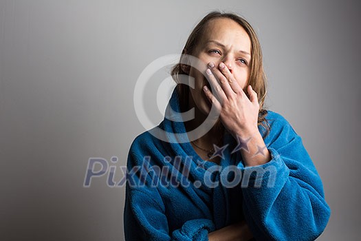 Sleepy young woman with wide open mouth yawning