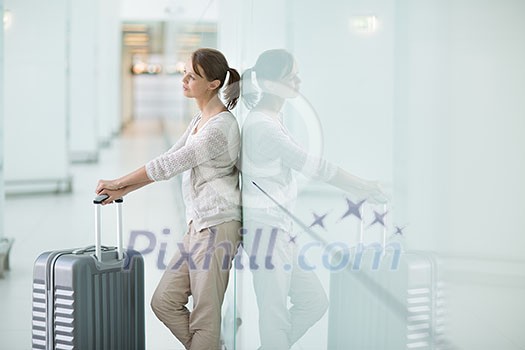 Young female passenger at the airport, waiting for her delayed flight Young female passenger at the airport, waiting for her delayed flight