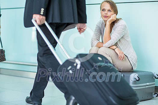 Young, female frustrated passenger at the airport, waiting desperately for her delayed flight (color toned image; shallow DOF) Young, female frustrated passenger at the airport, waiting desperately for her delayed flight (color toned image; shallow DOF)