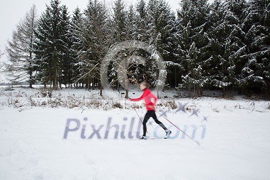Cross-country skiing: young woman cross-country skiing on a winter day (motion blurred image) Cross-country skiing: young woman cross-country skiing on a winter day (motion blurred image)