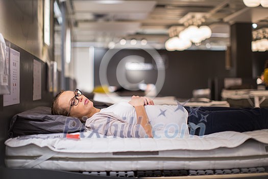 Pretty, young woman choosing the right furniture for her apartment in a modern home furnishings store (color toned image; shallow DOF) Pretty, young woman choosing the right furniture for her apartment in a modern home furnishings store (color toned image; shallow DOF)