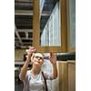 Pretty, young woman choosing the right furniture for her apartment in a modern home furnishings store (color toned image; shallow DOF)