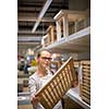 Pretty, young woman choosing the right furniture for her apartment in a modern home furnishings store (color toned image; shallow DOF)