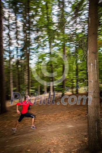 Young woman running outdoors in a forest, going fast (motion blurred image) Young woman running outdoors in a forest, going fast (motion blurred image)