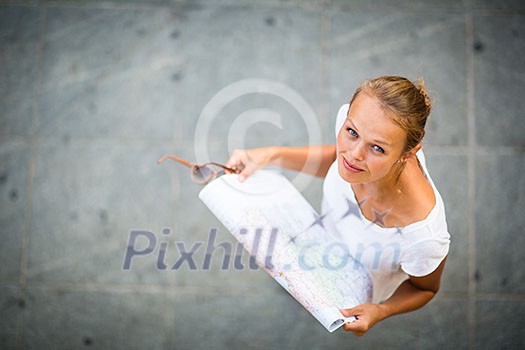 Pretty young female tourist studying a map, enjoying discovering a new city, looking excited (shallow DOF; color toned image) Pretty young female tourist studying a map, enjoying discovering a new city, looking excited (shallow DOF; color toned image)