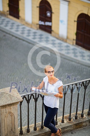 Pretty young female tourist studying a map, enjoying discovering a new city, looking excited (shallow DOF; color toned image) Pretty young female tourist studying a map, enjoying discovering a new city, looking excited (shallow DOF; color toned image)