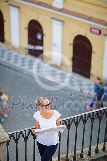 Pretty young female tourist studying a map, enjoying discovering a new city, looking excited (shallow DOF; color toned image) Pretty young female tourist studying a map, enjoying discovering a new city, looking excited (shallow DOF; color toned image)