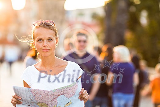 Pretty young female tourist studying a map, enjoying discovering a new city, looking excited (shallow DOF; color toned image) Pretty young female tourist studying a map, enjoying discovering a new city, looking excited (shallow DOF; color toned image)