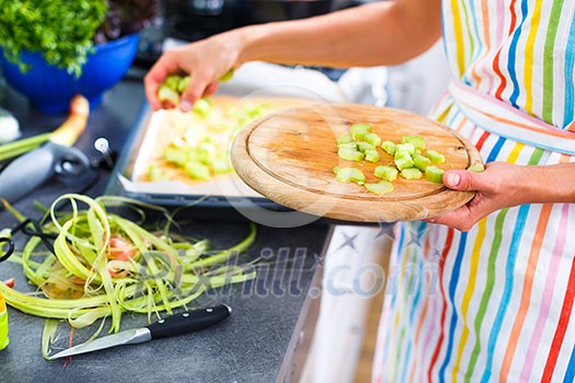 Young woman cooking in her modern kitchen (shallow DOF; color toned image) Young woman cooking in her modern kitchen (shallow DOF; color toned image)