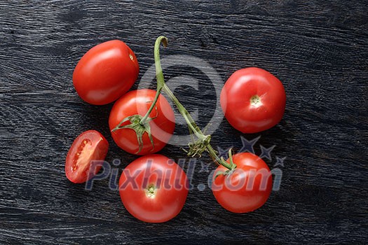 red tomatoes with green salad on dark wooden background red tomatoes with green salad on dark wooden background